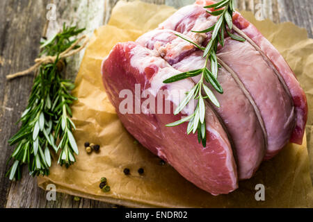 Organic pork lion roast with rosemary on wood farm table. Stock Photo