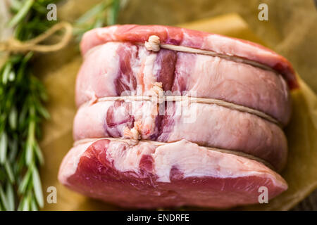 Organic pork lion roast with rosemary on wood farm table. Stock Photo