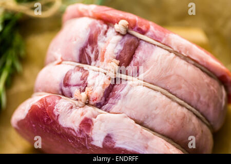 Organic pork lion roast with rosemary on wood farm table. Stock Photo