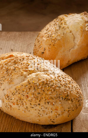 Rustic seeded baguettes small freshly baked bread rolls crusted with poppy and sesame seeds Stock Photo