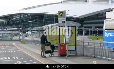 A commuter at an empty bus stop at  Dublin airport during a day of industrial action by drivers at Dublin Bus and Bus Eireann. Stock Photo