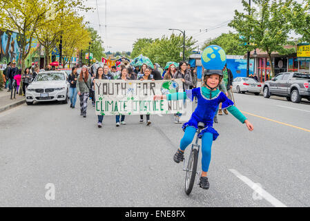Boy on unicycle, leads Earth Day Parade , Commercial Drive, Vancouver, B.C. Canada Stock Photo