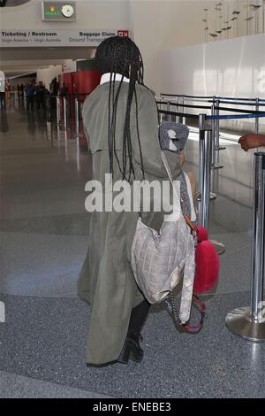 Zoe Kravitz wearing a long trench coat and blue tinted ...