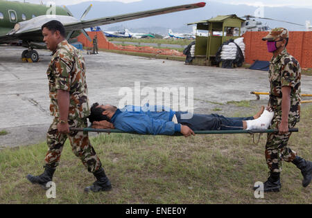 Nepal. 3rd May, 2015. Napoli Army carry and injured person at Tribhuvan International Airport in Kathmandu. A major 7.9 earthquake hit Kathmandu mid-day on Saturday, April 25th, and was followed by multiple aftershocks that triggered avalanches on Mt. Everest that buried mountain climbers in their base camps. Credit:  PixelPro/Alamy Live News Stock Photo