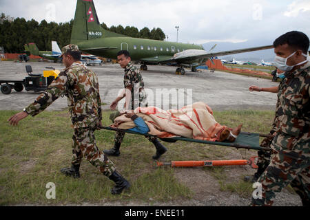 Nepal. 3rd May, 2015. Napoli Army carry and injured person at Tribhuvan International Airport in Kathmandu. A major 7.9 earthquake hit Kathmandu mid-day on Saturday, April 25th, and was followed by multiple aftershocks that triggered avalanches on Mt. Everest that buried mountain climbers in their base camps. Credit:  PixelPro/Alamy Live News Stock Photo