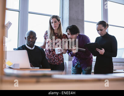 Business man working on a project with colleagues. Executives looking at laptop Stock Photo