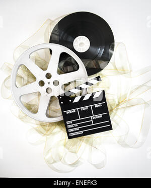 Movie clapper on 35 mm cinema reels unrolled filmstrip on neutral background Stock Photo