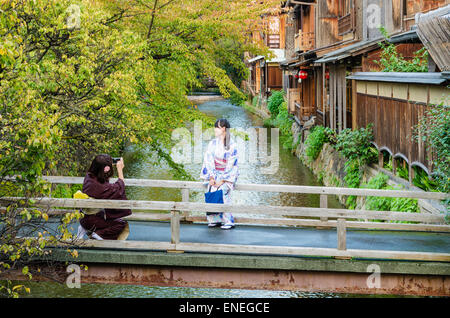 Traditionally dressed Japanese women taking photos of each other in the Shirakawa Area of Gion, Kyoto, Japan Stock Photo