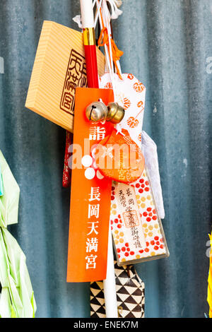 Several tiny drawstring like little bags, omamori, hanging at a Japanese shrine. The design of these protective charms is from the Heian era. Stock Photo