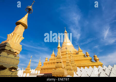 Golden Sandamuni Pagoda with row of white pagodas. Amazing architecture of Buddhist Temples at Mandalay. Myanmar (Burma) travel Stock Photo