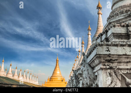 Golden Sandamuni Pagoda with row of white pagodas. Amazing architecture of Buddhist Temples at Mandalay. Myanmar (Burma) travel Stock Photo