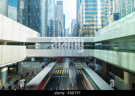Abstract futuristic cityscape view with modern skyscrapers, bridge and walking people. Hong Kong Stock Photo