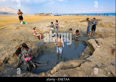 DEAD SEA, ISRAEL - OCT 13, 2014: People rub each other in with mud on the beach of the dead sea in Israel Stock Photo