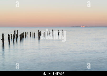 Beautiful calming long exposure landscape of ruined pier at sunset Stock Photo