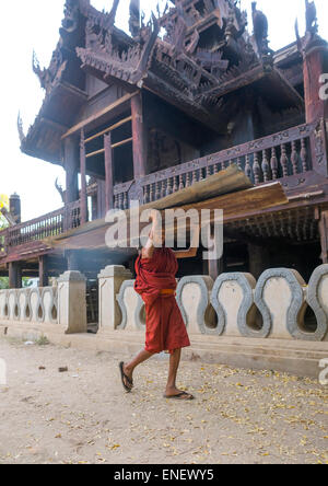 Novice Monk In Nat Taung Kyaung Monastery Carrying Furniture, Bagan, Myanmar Stock Photo