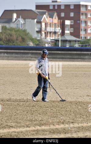 Male using metal detector on Lytham St Annes beach Stock Photo