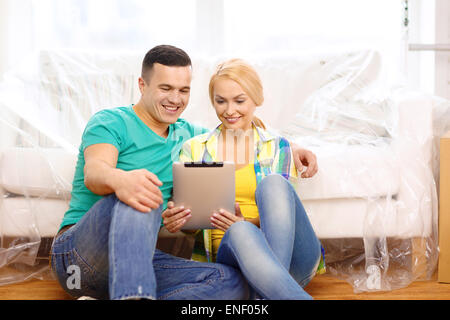 smiling couple with tablet pc in new home Stock Photo