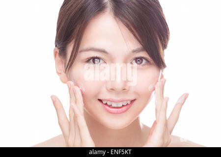 Beautiful Chinese woman applying cream to face. skincare concept Stock Photo