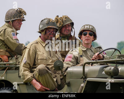 American US Allied Soldiers in WW2 Uniform seated in a Willys Jeep as part of the D-Day Anniversary, Normandy France Stock Photo