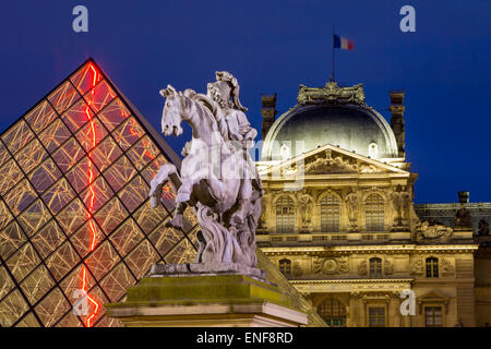 Twilight over Louis XIV Statue, the glass pyramid and Musee du Louvre, Paris, France Stock Photo