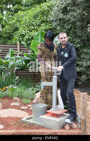 Pumping water for WaterAid, Ringo Starr with WaterAid worker from Malawi. RHS Chelsea Flower Show 2012 - Press Day. Stock Photo