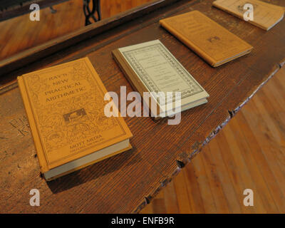 Schoolbooks and desk are part of a historic schoolroom display is at the Bennington Museum in Bennington, Vermont. Stock Photo