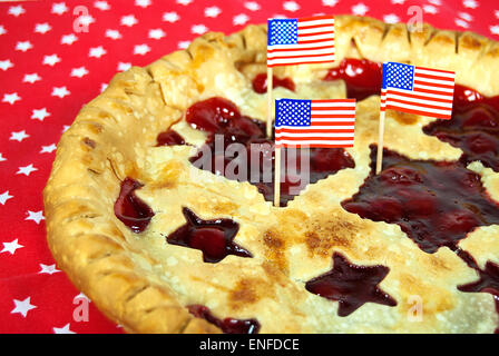 American flags on a red cherry pie with star cutouts in crust. Stock Photo