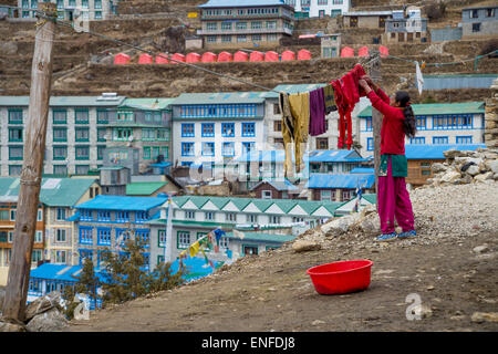 A Nepali woman hanging laundry on the washing line, in Namche Bazaar Stock Photo