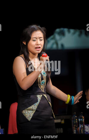 A young Chinese-Australian lady taking part in an on-stage karaoke competition as part of the Chinese New Year celebrations Stock Photo