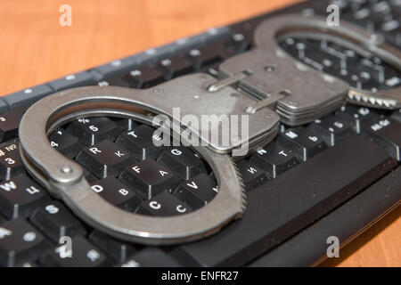 Handcuffs are on the computer keyboard Stock Photo