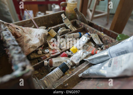 collection varied tubes old and new large small oil paints in artists studio much used with oil pot rim Stock Photo