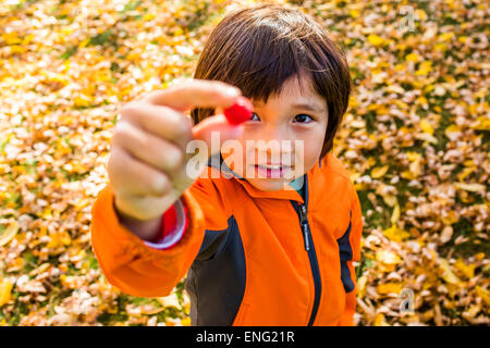 High angle view of mixed race boy holding berry Stock Photo
