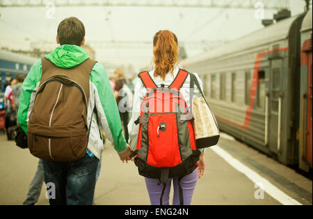 Caucasian couple holding hands on train station platform Stock Photo