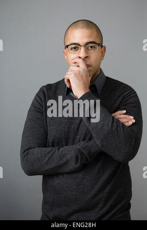 Mixed race man holding chin in hand Stock Photo