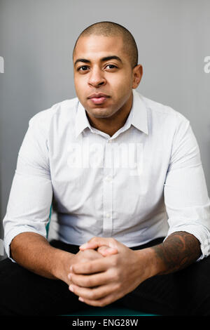 Close up of mixed race businessman with hands clasped Stock Photo