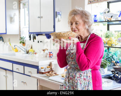 Older Caucasian woman baking pie in kitchen Stock Photo