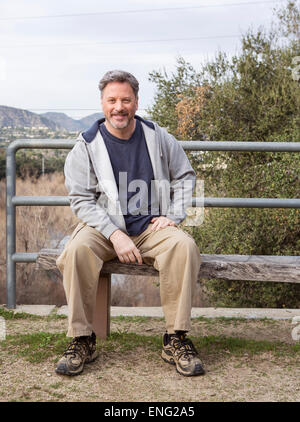 Caucasian man sitting on bench in park Stock Photo