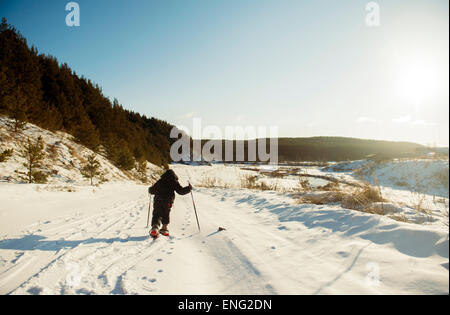 Caucasian boy cross-country skiing in snowy field Stock Photo