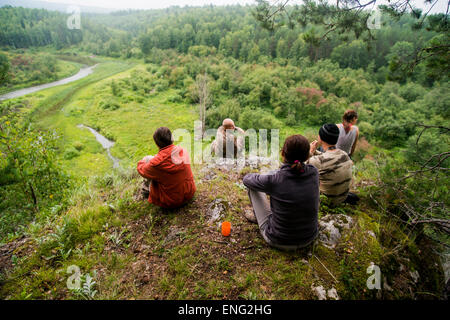 Caucasian friends admiring scenic view from rural hilltop Stock Photo