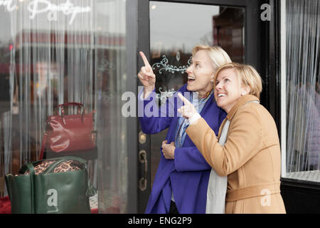 Older Caucasian women window shopping in clothing store Stock Photo