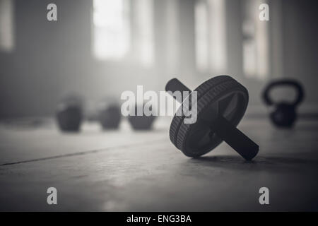 Close up of barbell weights on floor of dark gym Stock Photo