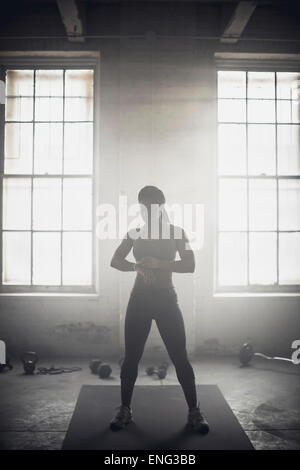 Black woman standing in dark gym Stock Photo