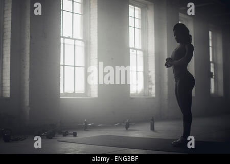 Black woman standing in dark gym Stock Photo