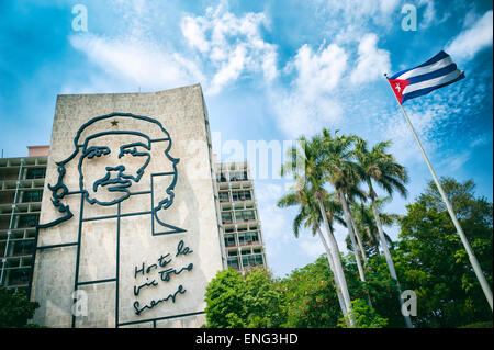 HAVANA, CUBA - JUNE 2011: Cuban flag flies next to large portrait of the revolutionary Che Guevara at the Plaza de la Revolucion Stock Photo