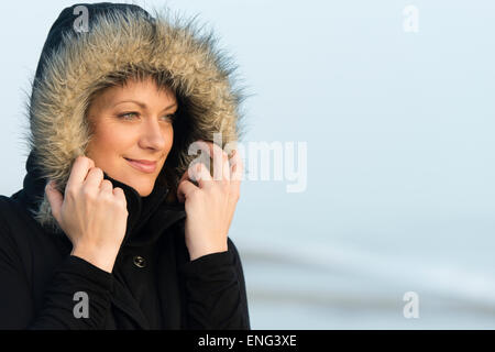 Caucasian woman wearing coat with fur hood outdoors Stock Photo