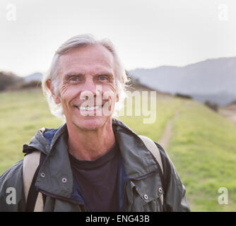 Older Caucasian man walking on dirt trail Stock Photo