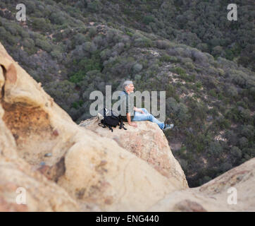 High angle view of older Caucasian man sitting on rock formation
