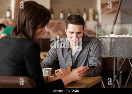 Couple using cell phone in cafe