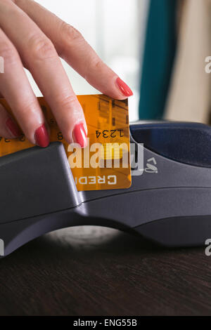 Close up of woman swiping credit card in credit card reader Stock Photo