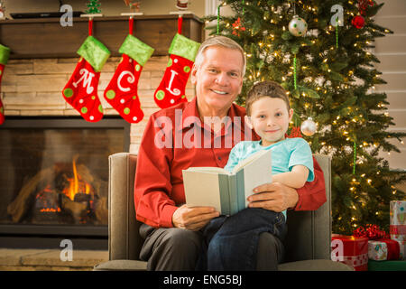 Caucasian grandfather reading to grandson at Christmas Stock Photo